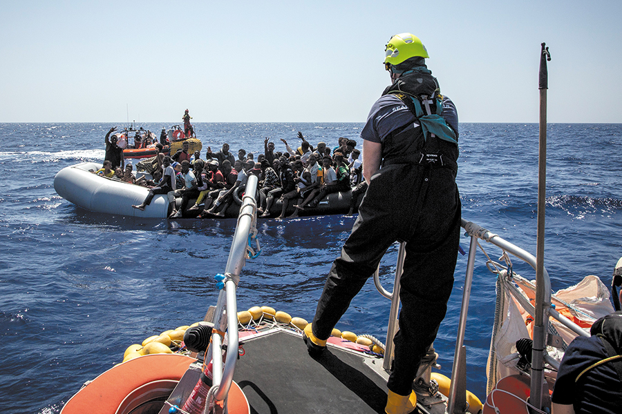 百多名難民坐滿吹氣筏，救援人員需駛出兩艘船至吹氣筏兩旁，避免他們因一時心急上船墮海。