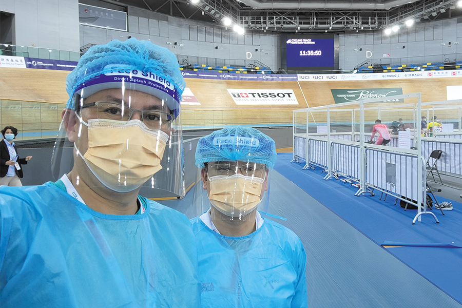 Dr Chau (left) wears full PPE while serving as MDD at an indoor cycling race during the epidemic.