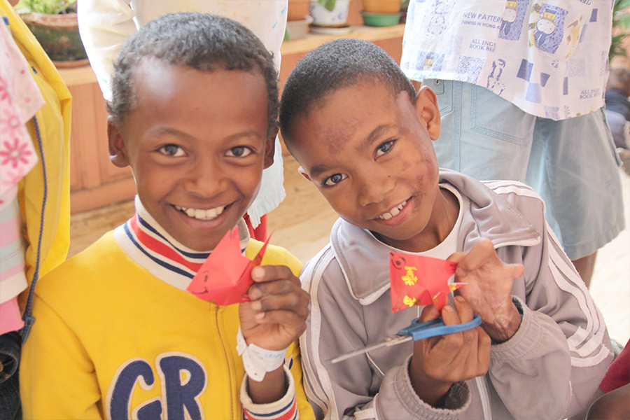 麥姑娘教當地小朋友摺紙。