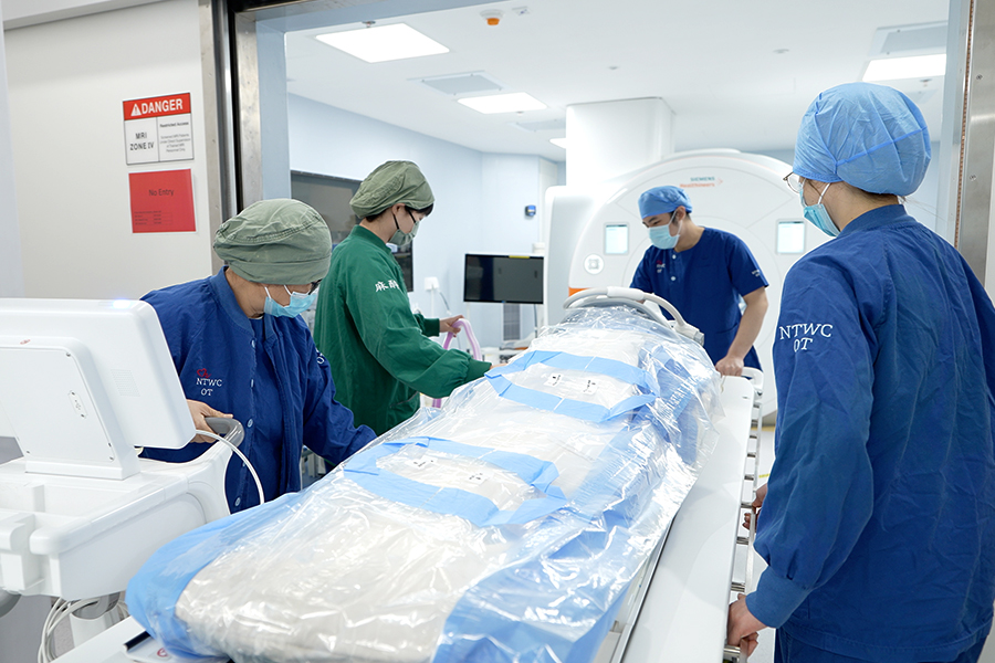 團隊在手術進行期間，將病人推入相連的掃描室進行磁力共振掃描。