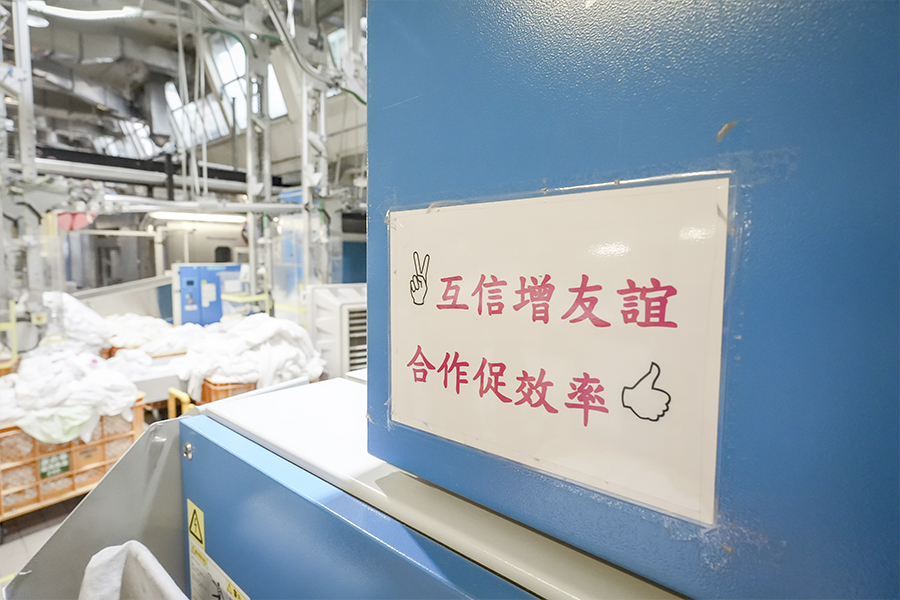 洗衣房四周都貼上標語,提醒員工彼此合作、注意安全。