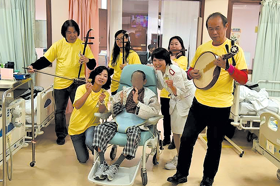 醫管局中樂團到病房表演，病人一起用鈴鼓奏樂。