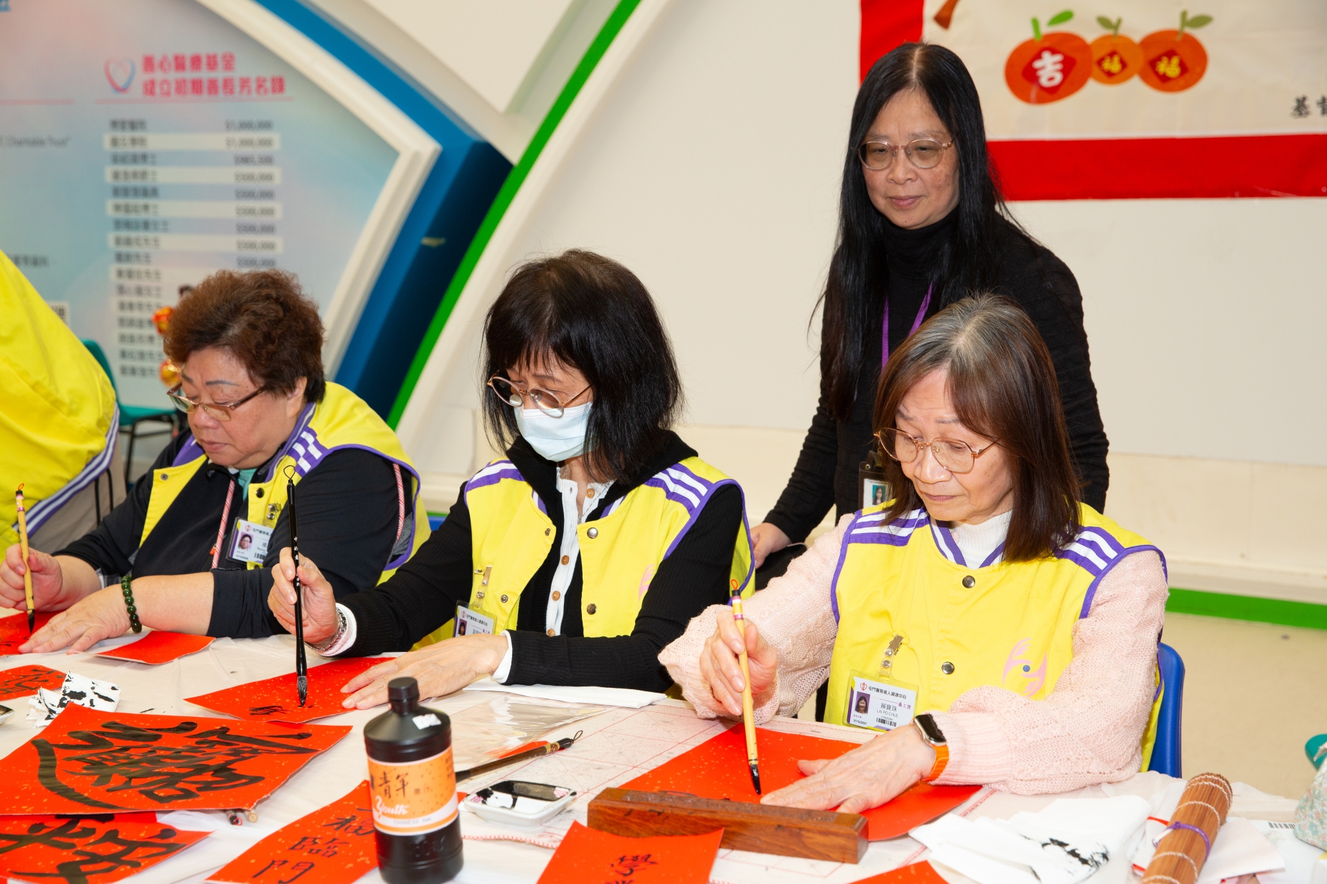 適逢新春，寶珠（右一）與一眾義工於醫院地下大堂寫揮春。